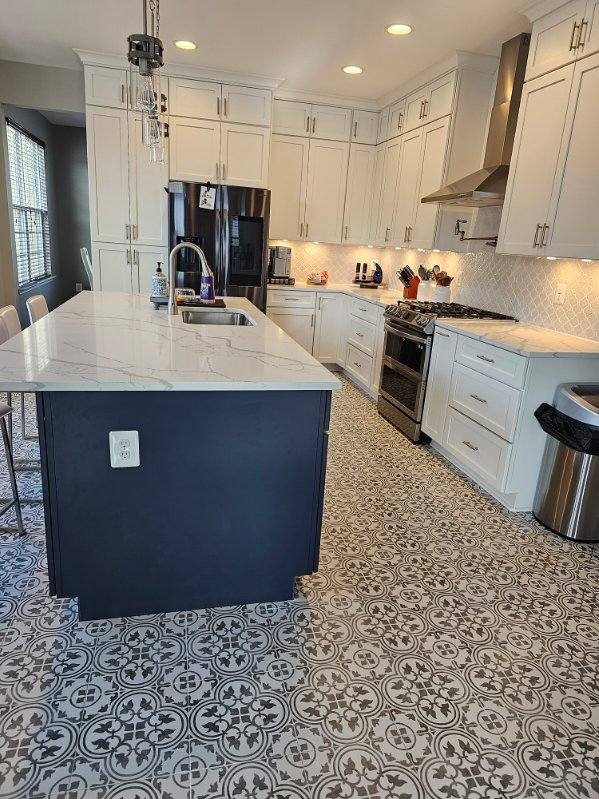 Modern white kitchen remodel in Northern Virginia featuring marble countertops and patterned tile flooring.