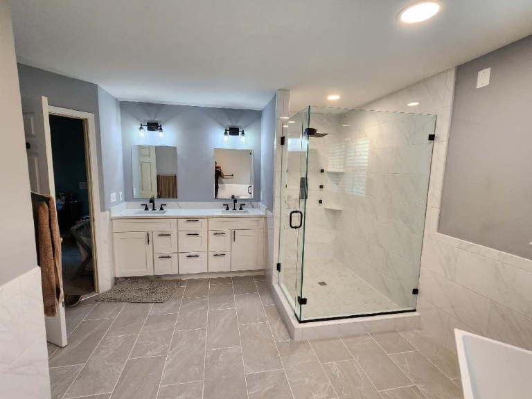 Modern bathroom with a spacious vanity, walk-in shower, durable tile, and organized storage