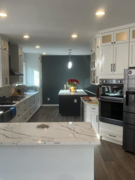 modern kitchen with custom cabinets, island, pendant lighting, and stainless steel appliances