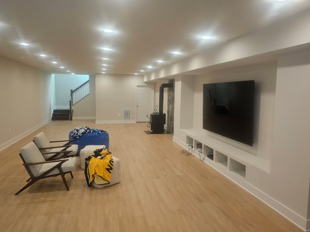 Finished basement with comfortable seating, bright lighting, and an open layout